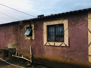 una casa con una ventana en un lado en Purple en Durban