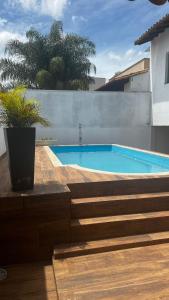a swimming pool with a potted plant next to a house at Casa Família Paraíso in Capitólio