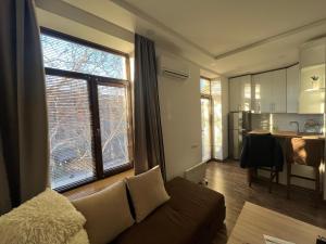 a living room with a couch and a large window at Cascade White Luxury Apartment in Yerevan