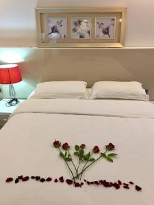 a white bed with a bouquet of roses on it at Yankı Hotel in Çekirge