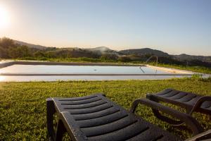 un banc assis dans l'herbe à côté d'une piscine dans l'établissement Agroturismo BASITEGI, à Urnieta