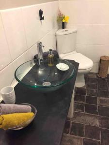 a bathroom with a glass sink and a toilet at Top Floor at Cantref House in Brecon