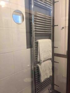 a bathroom with a shower with towels and a mirror at Top Floor at Cantref House in Brecon