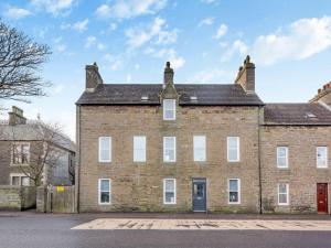 a large brick building with a red door at LANGLEY LODGE 7 Double Bedrooms with SMART TVs, 6 Bathrooms, Fully Equipped Kitchen, Ample PARKING, Wifi, dishwasher, Garden, GREAT CENTRAL LOCATION Ideal for BUSINESS and TRADES TEAMS For Long Stays contact Langley Cottages & Serviced Apartments VAT reg in Wick