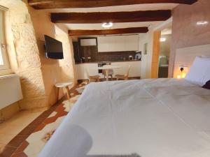 1 Schlafzimmer mit einem großen weißen Bett und einer Küche in der Unterkunft Coast 52 Savynomad Harbour Residences wow Views in Valletta