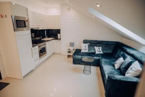 a living room with a couch and a kitchen at Apartament Kotwica in Giżycko