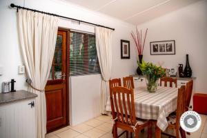 a dining room with a table and a kitchen at Wijnberg Cottage in Montagu