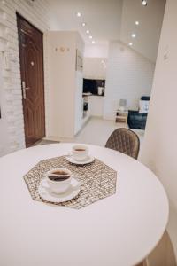 dos tazas de café sentadas en una mesa en Apartament Kotwica en Giżycko