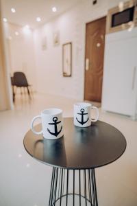 due tazze da caffè sedute sopra un tavolo di Apartament Kotwica a Giżycko