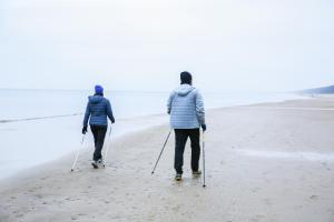 Due persone camminano sulla spiaggia di Jantar Medical Spa a Dziwnówek