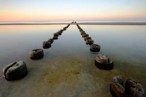 un muelle en el agua con rocas en el agua en Jantar Medical Spa, en Dziwnówek