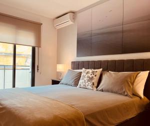 um quarto com uma cama grande e uma janela em Condomínio Ondas do Mar -Coastal Comfort- em Olhão