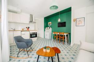 a kitchen and a living room with a table at Casita Valence - Petite maison de charme - Parking gratuit & Jardin Privé in Valence