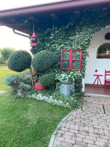 a house with a red window and plants at Casa vacanze Girardi in Gorizia