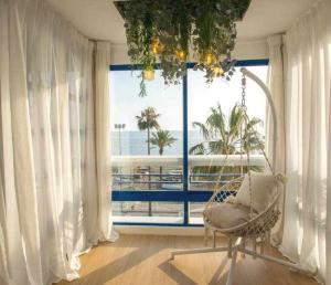 托羅克斯科斯塔的住宿－dúplex a la orilla del Mediterráneo，一间位于大窗户前的带椅子的房间