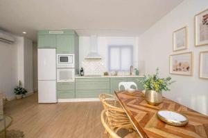 a kitchen with green cabinets and a wooden table at dúplex a la orilla del Mediterráneo in Torrox Costa
