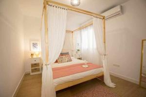 a bedroom with a canopy bed with curtains at dúplex a la orilla del Mediterráneo in Torrox Costa
