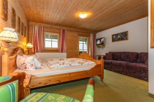 1 dormitorio con 1 cama y 1 sofá en Ferienwohnung Remberghof, en Viehhofen