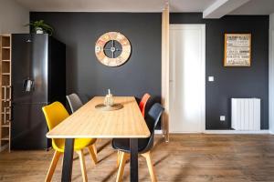 a dining room with a table and chairs and a clock at Life&Travel - Appartement Bordeaux - 4 chambres in Bordeaux