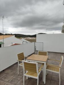 eine Terrasse mit einem Tisch und Stühlen auf dem Dach in der Unterkunft Apartamentos BARBAS in Villanueva de los Castillejos