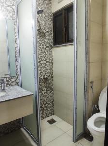 ein Bad mit einer Dusche und einem WC in der Unterkunft Hotel Daffodils in Rawalpindi