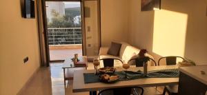 sala de estar con mesa y sofá en AYRA ROOMS ALIVERI, en Aliveri