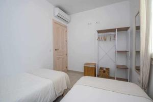 Biała sypialnia z 2 łóżkami i szafą w obiekcie Casa Marinero beach 1 w mieście Torrox Costa