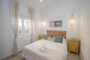 a white bedroom with a bed and a window at Casa Marinero beach 2 in Torrox Costa