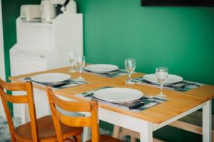 una mesa de madera con platos y copas de vino. en Casita - Comme une petite maison - Parking gratuit, en Valence