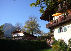 un edificio con balcón y una montaña en el fondo en Haus Brandstein Ferienwohnungen en Ramsau