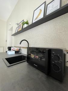 una cucina con forno a microonde nero e piano cottura di Diverso Apartment a Caiazzo