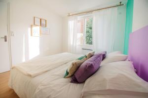 a bedroom with a bed with pillows and a window at Casita - Comme une petite maison - Parking gratuit in Valence