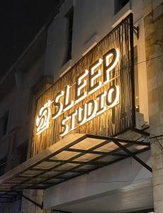 a neon sign on the side of a building at Sleep Studio Hotel City Center Surabaya in Tembok