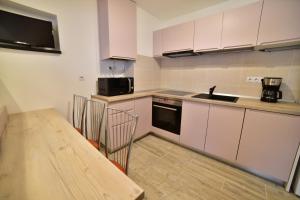 una cucina con tavolo in legno e piano di lavoro di Apartament 3 camere, Schiller Residence, Piata Mare a Sibiu