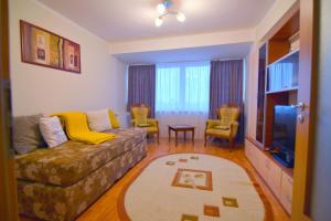 a living room with a couch and chairs and a tv at Apartment superb intr-o locatie premium in Timişoara