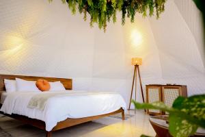 Alma Glamping في اسكازو: غرفة نوم بسرير ذو شراشف بيضاء