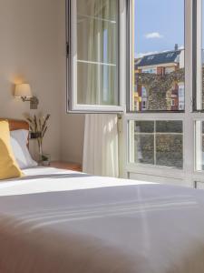 a bedroom with a bed and two large windows at Hostal ALBA Lugo in Lugo