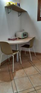 a kitchen table with a microwave and two chairs at Il Ghiandolino in Imola
