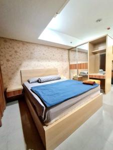 ein Schlafzimmer mit einem großen Bett in einem Zimmer in der Unterkunft La Grande Merdeka Apartment in Bandung