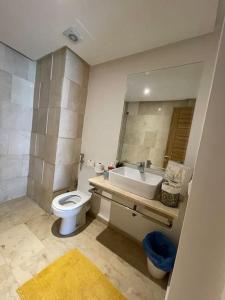 uma casa de banho com um WC branco e um lavatório. em Chic & cosy Flat Near Airport lockbox fast wifi em Nouaceur