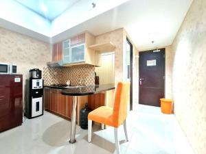 eine Küche mit einem Tisch und einem Stuhl in einem Zimmer in der Unterkunft La Grande Merdeka Apartment in Bandung