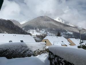 a view of a snow covered mountain range with houses at Chalet tout confort 3 chambres in Cauterets