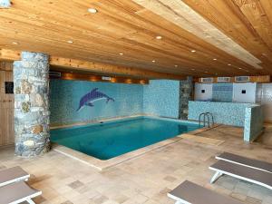 a swimming pool with a dolphin on the wall at Hôtel L'Aigle du Montana by Les Etincelles in Tignes