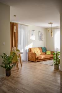sala de estar con sofá y mesa en Greenside SunPark Apartament en Przemyśl
