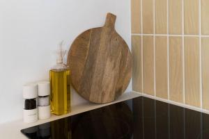 a shelf with a wooden spoon and a bottle of oil at Boutique Central Margate Apt. - edge of Old Town! in Margate
