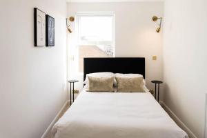 a bedroom with a large white bed with two pillows at Boutique Central Margate Apt. - edge of Old Town! in Margate
