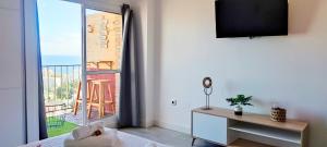 een woonkamer met een tv en een balkon bij NORDIC SUITE Apartamentos Minerva NEW APARTMENT Vistas al Mar in Benalmádena