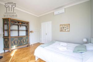a white bedroom with a bed and a window at Vittoria Apartments: Viale Dante in Vicenza +2 photos