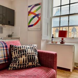The Nook في نورث بيرويك: غرفة معيشة مع أريكة حمراء ونافذة