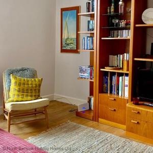sala de estar con silla y estante para libros en The Nook, en North Berwick